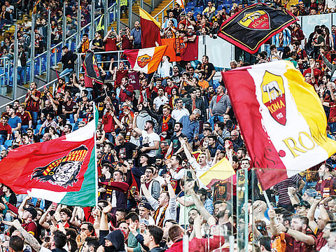 Roma fans wave flags in support of their team.