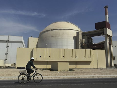 A worker rides a bike in front of the reactor building of the Bushehr nuclear power plant, just outside the southern city of Bushehr, Iran in this 2010 file photo.