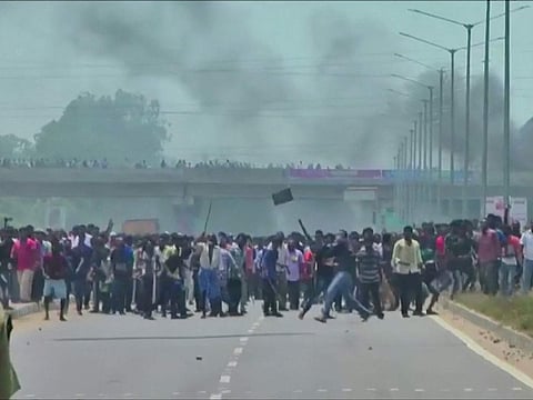 People pelt stones during a protest against the construction of a copper smelter by Vedanta Resources from the road, in Thoothukudi, Tamil Nadu, India in this still image from May 22, 2018 video footage.