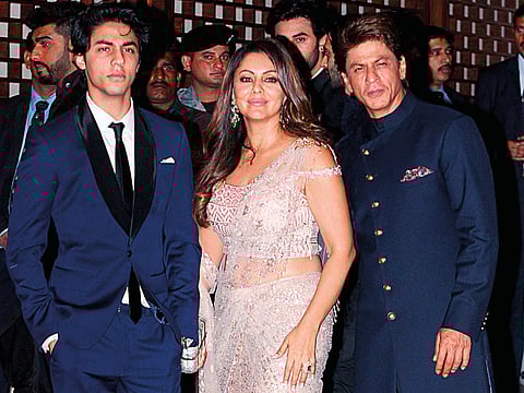 Indian actor Shah Rukh Khan (right) poses for a picture with his wife Gauri Khan and son Aryan Khan as they attend the pre-engagement party of Reliance Industries Limited Chairman, Mukesh Ambani’s eldest son Akash Ambani and Shloka Mehta, in Mumbai on June 30, 2018.