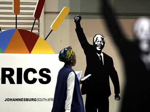 A journalist walks past a placard of Nelson Mandela during a previous BRICS Summit in Johannesburg, South Africa (File)