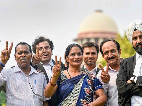 Nirbhaya's parents show the victory sign after the Supreme Court's verdict on the December 2012 gang rape case, in New Delhi, in July 2018.