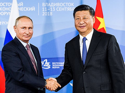 Russian President Vladimir Putin shakes hands with Chinese President Xi Jinping