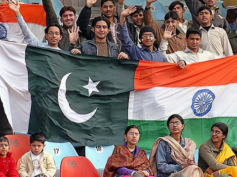 Cricket fans hold Pakistani and Indian flags.