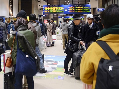 Passengers check the timetable after an earthquake stopped and delayed some train services at JR Kumamoto station in Kumamoto, western Japan, Thursday, Jan. 3, 2019.