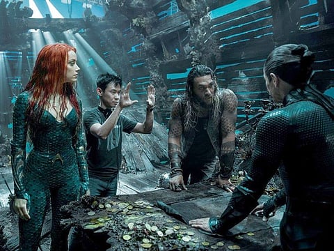 James Wan, second from left, directs a scene in "Aquaman" with, from left, Amber Heard, Jason Momoa and Willem Dafoe.