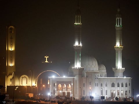 Minarets of a mosque and a cross on top of a church are seen during cold weather before Sunday's Coptic Christmas Eve Mass in Cairo