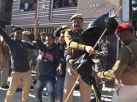 Assam Police personnel remove black flags from Krishak Mukti Sangram Samiti (KMSS) activists protesting with 69 other indigenous organizations of Assam during a demonstration against the Citizenship Amendment Bill 2016, which will provide citizenship or stay rights to minorities from Bangladesh, Pakistan and Afghanistan in India, in Guwahati on January 7, 2019. Thousands of people across northeastern Assam state on January 7 joined protests by around 30 different student and indigenous organisations against Indian government's controversial announcement to grant citizenship to religious minorities who moved to the state from neighbouring countries.