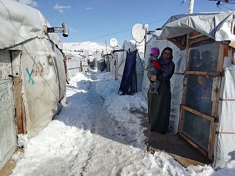 A Syrian refugee woman holds her baby as she stands in front of her tent at a makeshift camp at the Lebanese border town of Arsal, Lebanon January 9, 2019