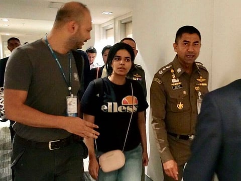 Surachate Hakparn, right, walks with Saudi woman Rahaf Mohammad Alqunun before leaving the Suvarnabhumi Airport in Bangkok, Thailand. Australia says it is considering granting the Saudi who fled from her family refugee resettlement based on referral by the U.N.