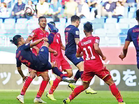 Thailand's defender Adison Promrak (L) kicks the ball during the 2019 AFC Asian Cup group A football match between Bahrain and Thailand at the Maktoum Bin Rashid Al Maktoum Stadium in Dubai on January 10, 2019.