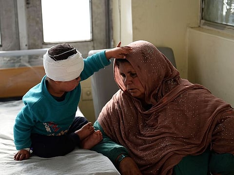An Afghan woman sits next to a wounded child after receiving treatment at Indira Gandhi Children’s Hospital after a powerful truck bomb attack in Kabul on January 15, 2019.
