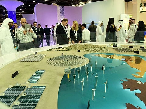 Visitors check out a solar project by Masdar City in their pavilion during the Abu Dhabi Sustainability Week at Adnec.