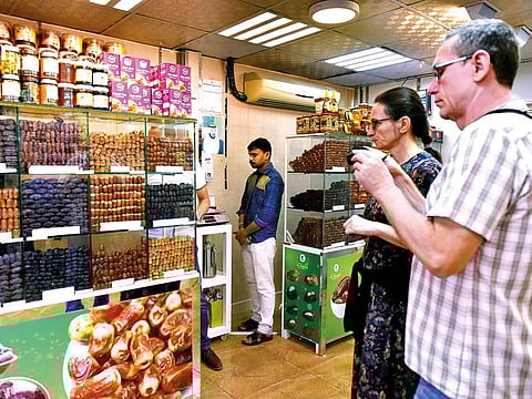 Ivan Susulik (right) and his wife from the Czech Republic at a shop in Mina Vegetable and Fruits Markets’ dates souq. They were impressed by the variety of dates sold at the market.