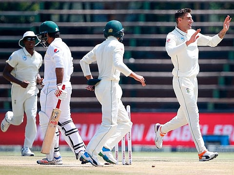South African bowler Duanne Olivier (R) celebrates the dismissal of Pakistan batsman Sarfraz Ahmed (CL) during the fourth day of the third Cricket Test match between South Africa and Pakistan at Wanderers cricket stadium on January 14, 2019 in Johannesburg.