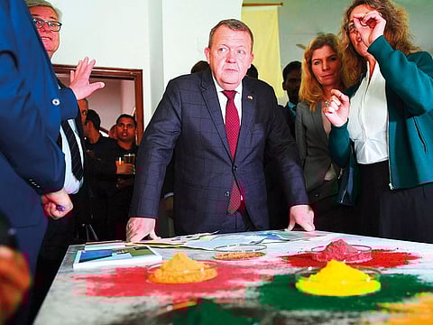 Denmark Prime Minister Lars Lokke Rasmussen (left) looks at colour powders for an art installation during the inauguration of the Danish Cultural Institute in New Delhi.