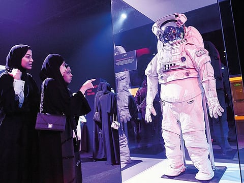 Visitors looking at the Extravehicular Mobility Unit, a space suit that provides environmental protecton, mobility, life support and communications for astronauts outside the spacecraft, at the Mohammad Bin Rashid Space Centre's Science event in Dubai
