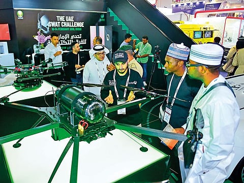 Visitors examine the Dubai Police drones at the Dubai Police stand at Intersec 2019