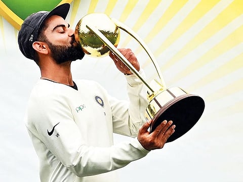 In this file photo taken on January 7, 2019 India's captain Virat Kohli kisses the Border-Gavaskar trophy as the Indian team celebrate their series win on the fifth day of the fourth and final cricket Test against Australia at the Sydney Cricket Ground in Sydney.