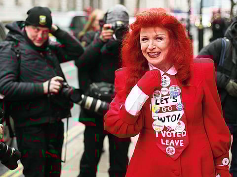 A pro-Brexit protester wearing ‘I Voted Leave’ and other slogans on her tie poses for a photograph in London.