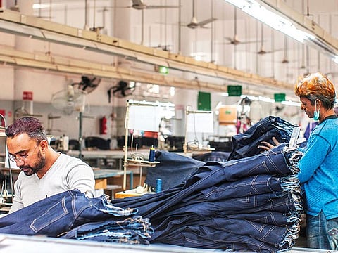 A garment worker handles jeans at a factory in Karachi.