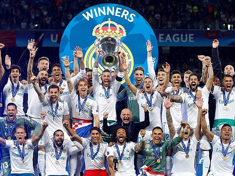 Real Madrid celebrate winning the Champions League with the trophy.