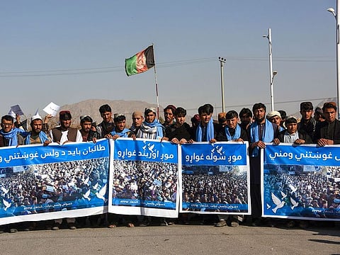 Afghan protesters march for peace and ceasefire as they hold banners in the Kandahar province on January 17, 2019.