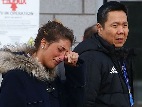 Cardiff City FC Executive Director and CEO Ken Choo (R) walks with Romina Sala (L), sister of Cardiff City's missing Argentinian footballer Emiliano Sala, whose flight disappeared from radar over the English Channel north of Guernsey, as they visit the tributes to Emiliano Sala layed outside Cardiff City Stadium in Cardiff, south Wales on January 25, 2019.