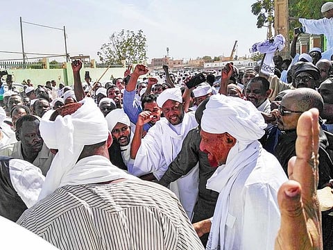 Sadiq Al Mahdi (right), Sudan’s ex-prime minister, leaves a mosque during a demonstration in Omdurman on Friday.