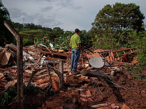 People from the community of Parque da Cachoeira look at debris in the mud-hit area a day after the collapse of a dam at an iron-ore mine belonging to Brazil's giant mining company Vale near the town of Brumadinho in the state of Minas Gerias in southeastern Brazil, on January 26, 2019.
