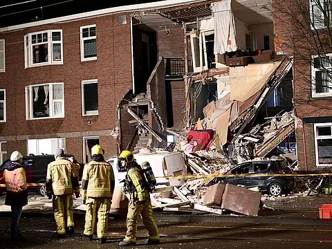 Firefighters walk outside of a partially collapsed building after an explosion in the Hague, the Netherlands, January 27, 2019.
