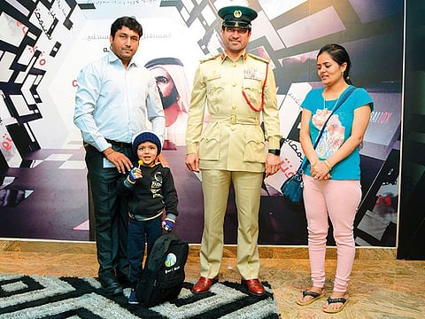 Brigadier Saeed Hamad Bin Sulaiman with the five-year-old boy and his parents at Al Rashidiya police station.
