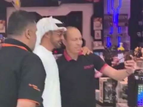 Staff at a Yas Mall shop take a selfie with Shaikh Mohammad Bin Zayed.