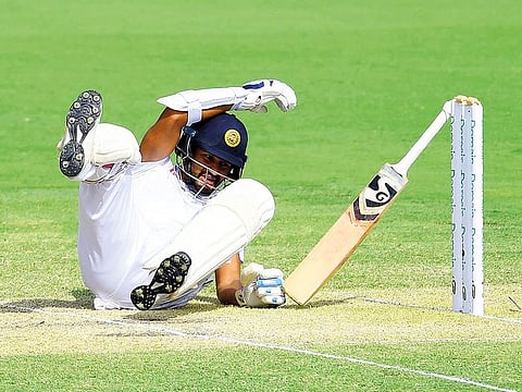 Sri Lanka’s Dimuth Karunaratne falls after being hit by a bouncer from Australia’s Pat Cummins during the second day at Manuka Oval Cricket Ground in Canberra.