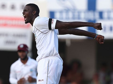 West Indies' captain Jason Holder celebrates taking the wicket of England's James Anderson on day three of the second Test cricket match at the Sir Vivian Richards Stadium in North Sound, Antigua and Barbuda, Saturday, Feb. 2, 2019.