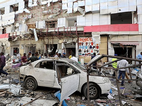 Somali security forces walk through the scene of an explosion in Mogadishu