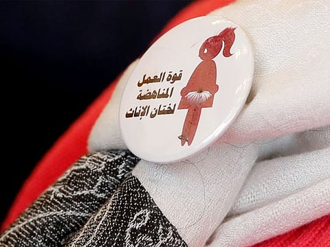 A badge reads "The power of labor against FGM" is seen on a volunteer during a conference on International Day of Zero Tolerance for Female Genital Mutilation (FGM) in Cairo