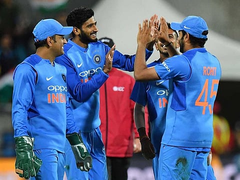 India's Khaleel Ahmed (2nd L) celebrates with Mahendra Singh Dhoni (L) and Rohit Sharma (R) after taking a catch off New Zealand's Ross Taylor during the first Twenty20 cricket match between New Zealand and India in Wellington on February 6, 2019.