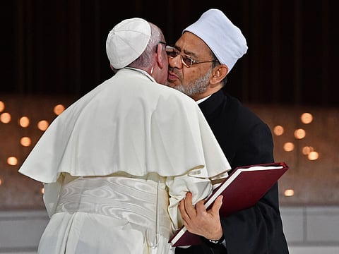 Pope Francis (L) and Egypt's Azhar Grand Imam Sheikh Ahmed al-Tayeb greet each other as they exchange documents during the Human Fraternity Meeting at the Founders Memorial in Abu Dhabi on February 4, 2019. Pope Francis rejected "hatred and violence" in the name of God, on the first visit by the head of the Catholic church to the Muslim-majority Arabian Peninsula. / AFP / Vincenzo PINTO