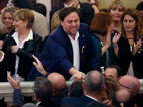 Catalan Vice President Oriol Junqueras, center, is greeted after a vote on independence in the Catalan parliament in Barcelona, Spain. Spain's Supreme Court is bracing to hold the nation's most sensitive trial in four decades of democracy this week with all eyes focused on its ability to stand up to concerted campaign by Catalonia's separatists to attack its credibility. Twelve high-profile Catalan separatists will face charges including rebellion for their role in a failed attempt to achieve secession for the prosperous north-eastern region in 2017.