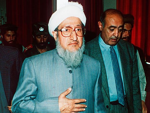 In this April 29, 1992, file photo, then Afghan President Sibghatullah Mujadidi leaves the Foreign Ministry in Kabul, Afghanistan, after briefing foreign diplomats on his first full day in power.