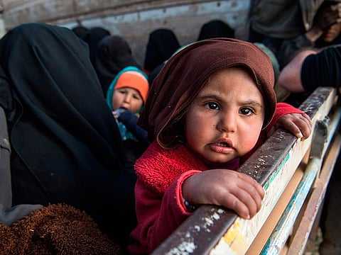 Women and children fleeing from the last Islamic State group’s tiny pocket in Syria sit in the back of a truck near Baghuz, eastern Syria, on February 11, 2019.