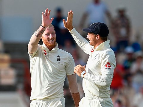 Ben Stokes (L) and Jos Buttler (R) of England celebrate the dismissal of Shannon Gabriel of West Indies.