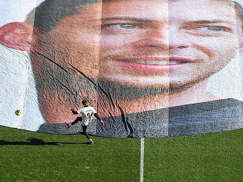 A player trains in front of the portrait of late Argentinian forward Emiliano Sala prior to the French L1 football match between FC Nantes and Nimes Olympique at the La Beaujoire stadium in Nantes, western France on February 10, 2019.