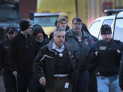 Workers are escorted from the property after a shooting the Henry Pratt Company on February 15, 2019 in Aurora, Illinois