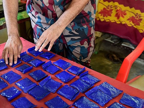 is file photo taken on April 6, 2018 shows a Bangladesh Border Guard (BGB) laying out small bags of the drug "yaba"