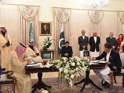 Pakistan's Prime Minister Imran Khan (foreground R) and Saudi Arabian Crown Prince Mohammad bin Salman (foreground L) look at their delegation members during a signing of a memorandum of understanding.