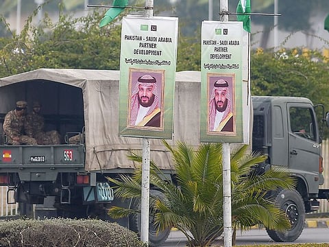 Pakistani soldiers patrol on a street next to welcoming posters of Saudi Arabian Crown Prince Mohammad Bin Salman in Islamabad on Sunday.