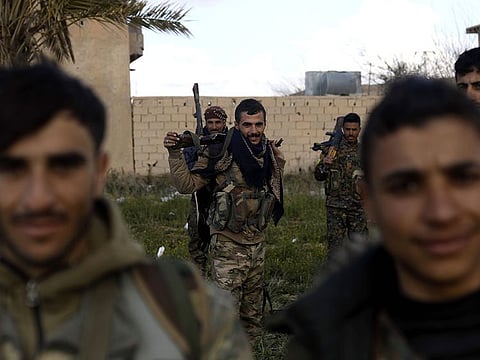 Kurdish fighters of the US-backed Syrian Democratic Forces (SDF) take a rest in the frontline Syrian village of Baghouz. SDF forces have been fighting against the last shred of Daesh in eastern Syria