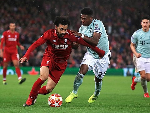 Liverpool's Mohammad Salah , left and Bayern Munich's David Alaba battle for the ball.